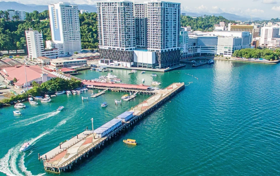 Aerial view of Jesselton Ferry Terminal in Kota Kinabalu, showing the piers, boats, and surrounding waterfront